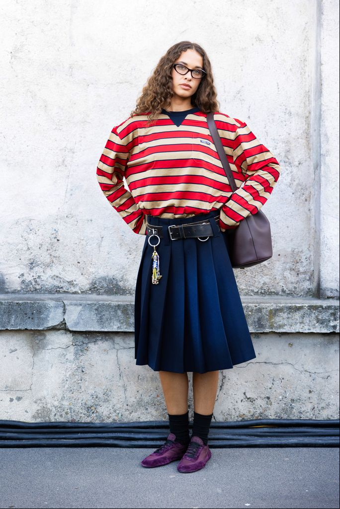 Sarah Lysander con falda vaquera, sudadera de rayas y zapatillas moradas